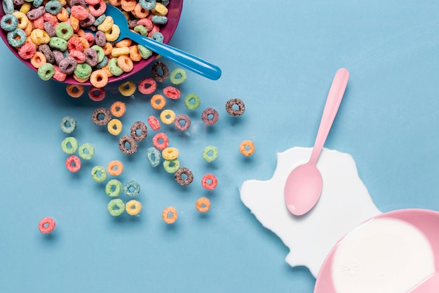 Tazón de cereales y salpicaduras de leche con cuchara rosa