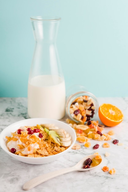 Tazón de copos de maíz de alto ángulo con yogur y frutas secas