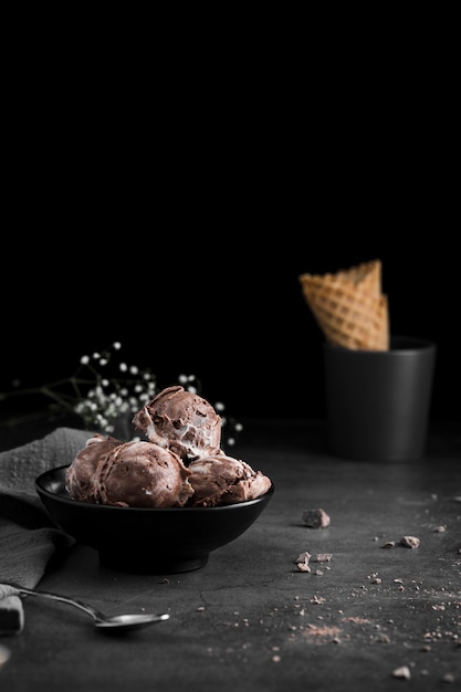 Tazón con cuchara de helado y taza con cono de helado