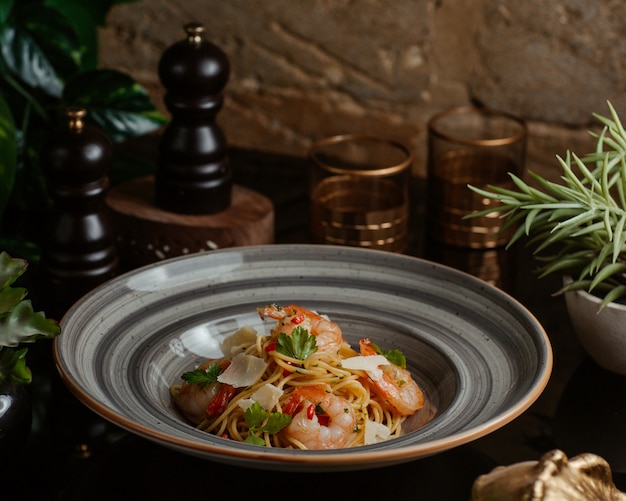 Tazón de fideos con mariscos, albahaca verde y parmesano