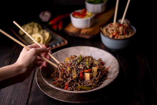 Tazón de fideos con verduras y otra comida asiática