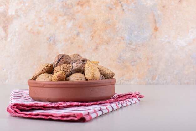 Tazón de fuente de almendras y nueces orgánicas sin cáscara en el fondo blanco. Foto de alta calidad