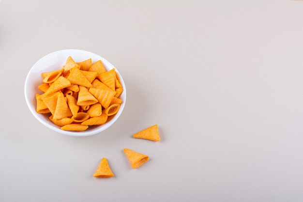 Tazón de fuente blanco de chips triangulares sobre fondo de mármol. Foto de alta calidad