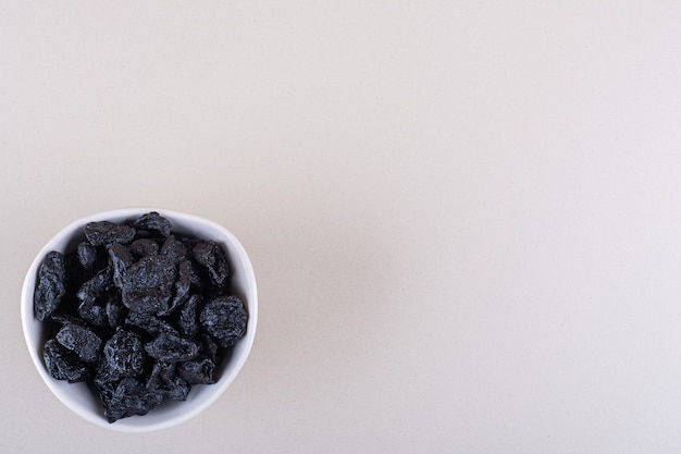 Foto gratuita tazón de fuente blanco de frutos secos de ciruela colocados sobre fondo blanco. foto de alta calidad