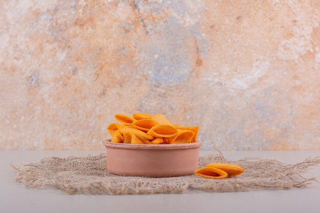 Tazón de fuente de chips crujientes triangulares colocados sobre fondo de mármol. Foto de alta calidad