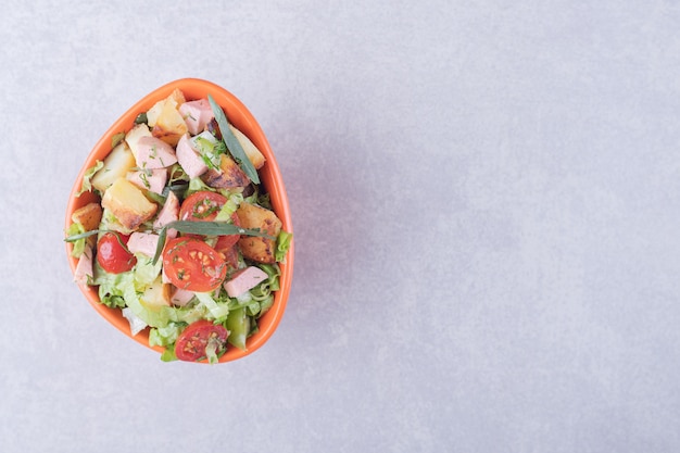 Foto gratuita tazón de fuente de ensalada fresca con salchichas sobre fondo de mármol.