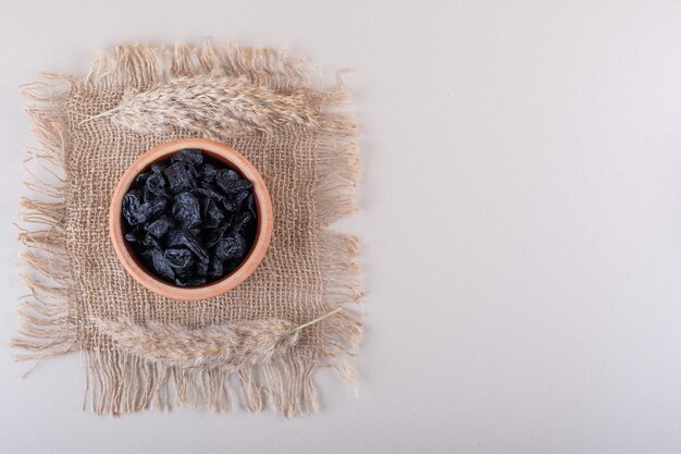 Tazón de fuente de frutos secos de ciruela colocados sobre fondo blanco. Foto de alta calidad