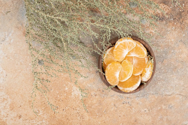 Foto gratuita tazón de fuente de gajos de mandarina fresca sobre fondo de mármol.