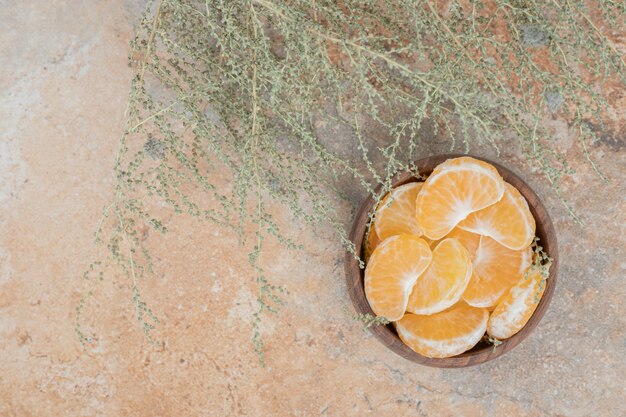 Foto gratuita tazón de fuente de gajos de mandarina fresca sobre fondo de mármol.