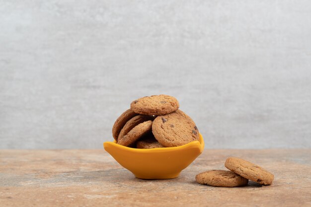 Tazón de fuente de galletas de chispas de chocolate sobre fondo de mármol.