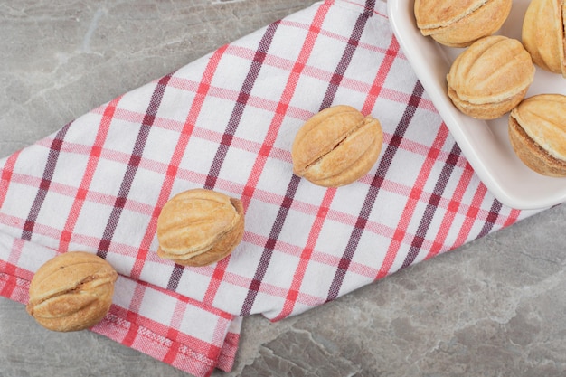 Tazón de fuente de galletas en forma de nuez sobre mantel.