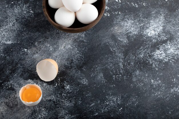 Tazón de fuente de huevos blancos y yema sobre la superficie de mármol.