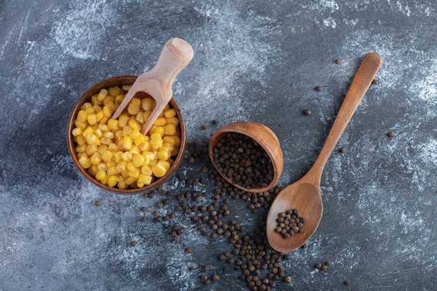 Tazón de fuente de maíz dulce y pimientos de grano en mármol.