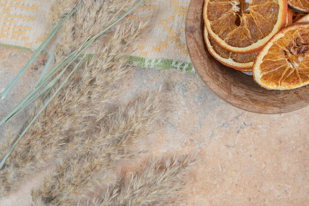 Tazón de fuente de rodajas de naranja con mantel sobre fondo de mármol.