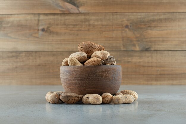 Tazón de fuente de varios frutos secos en la mesa de mármol. Foto de alta calidad