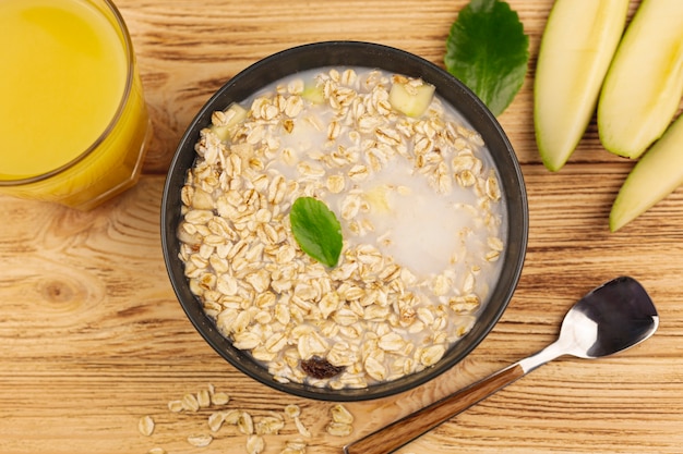 Foto gratuita tazón de gachas de avena con una taza de jugo de naranja