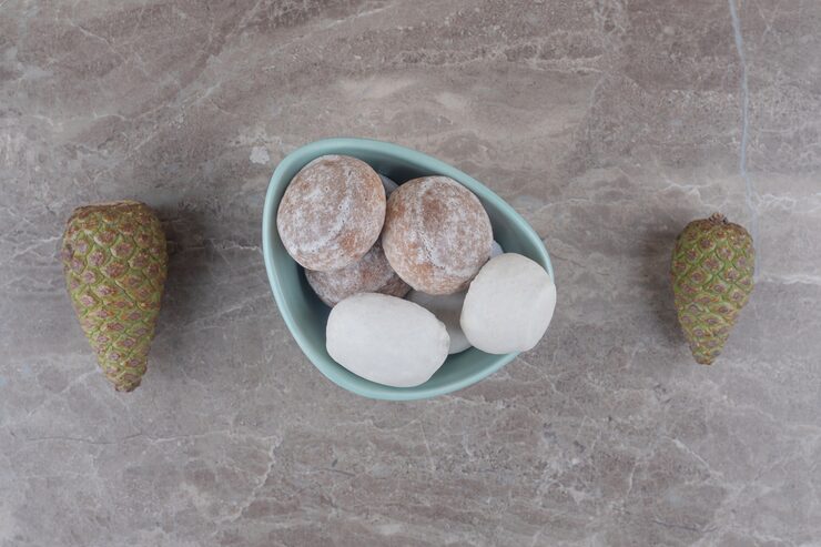 Foto gratuito un tazón de galletas junto a piñas en mármol