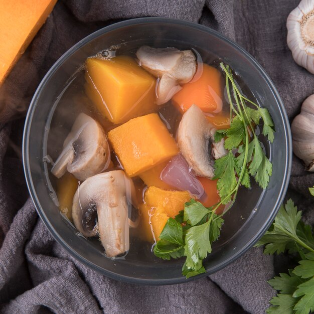 Tazón con ingredientes de sopa y primer plano de caldo