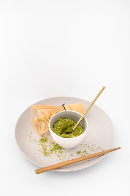 Tazón lleno de polvo de matcha en un plato