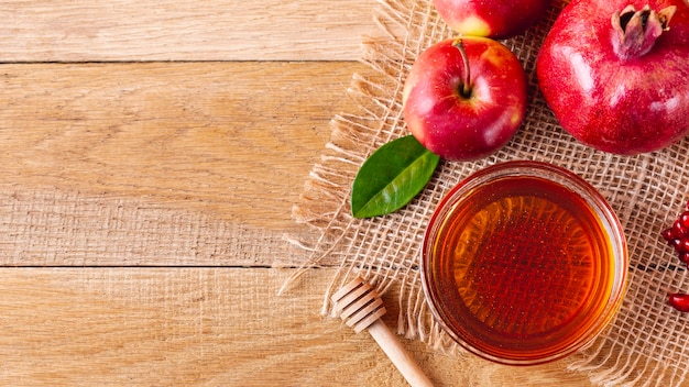 Tazón de miel con cucharón y frutas con espacio de copia