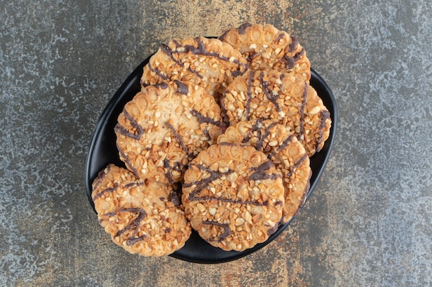 Foto gratuita un tazón negro con deliciosas galletas crujientes.