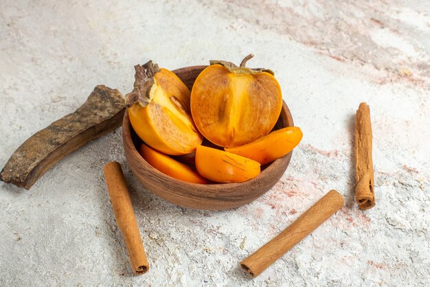 Tazón de palitos de palma y canela sobre mármol blanco