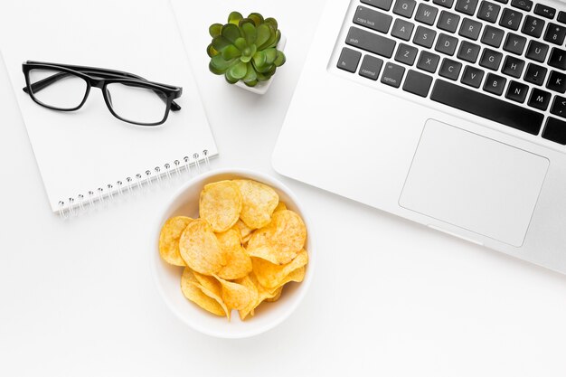 Tazón con papas fritas en el escritorio