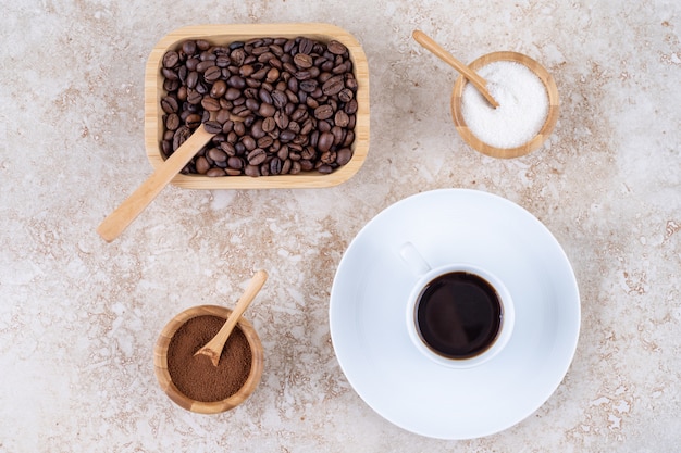 Un tazón pequeño de azúcar junto a varias formas de café.