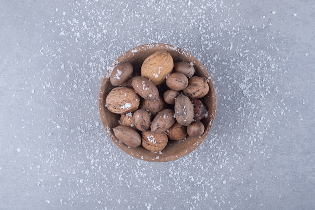 Foto gratuita tazón pequeño de nueces variadas sobre superficie de mármol