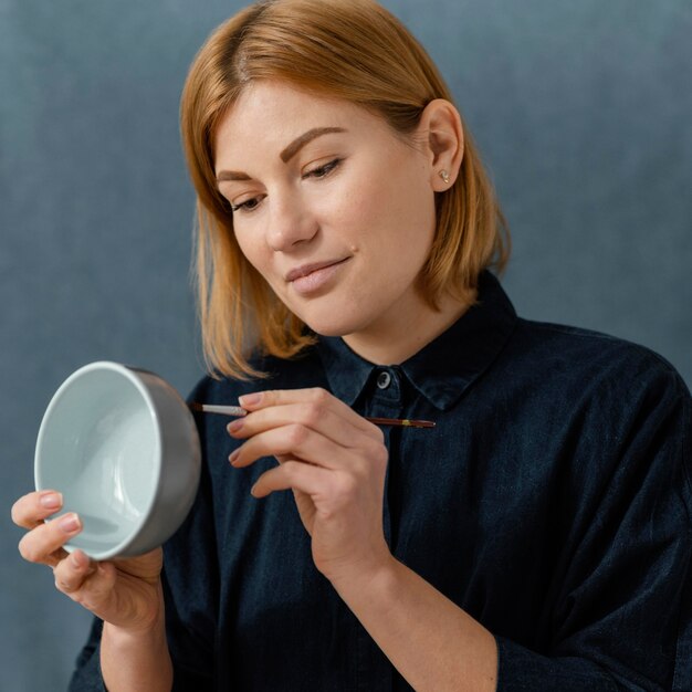 Foto gratuita tazón de pintura de mujer joven de tiro medio