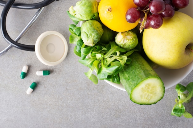 Tazón de primer plano con frutas y verduras y pastillas