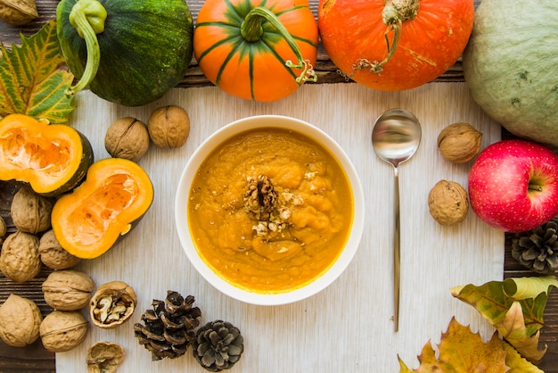 Tazón de puré de calabaza en mesa decorada