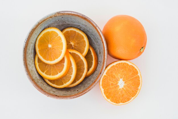 Tazón de rodajas de naranja en blanco