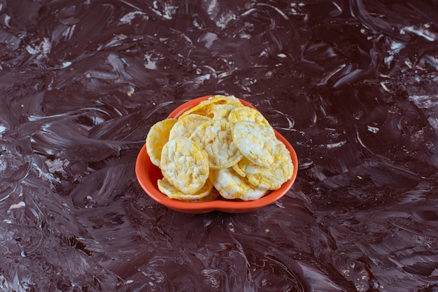 Foto gratuita un tazón de sabrosas chips de queso en la superficie de mármol