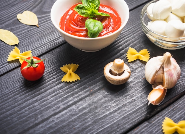 Tazón de salsa de tomate con albahaca e ingredientes