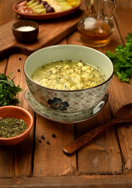 Tazón de sopa de albóndigas dushbara azerbaiyana tradicional servida con vinagre y menta seca