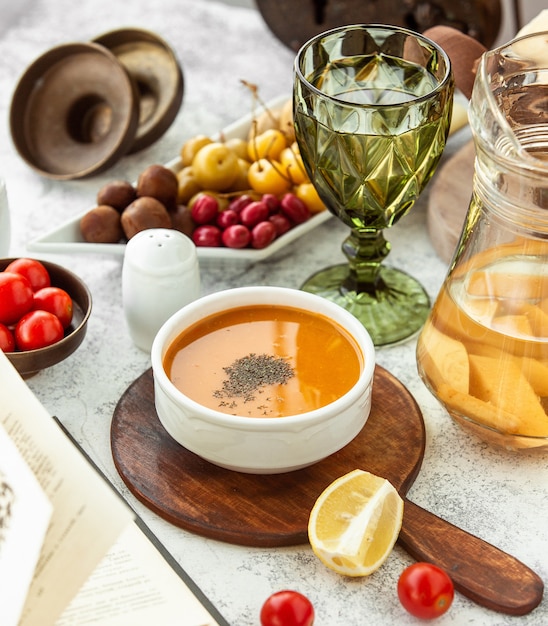 tazón de sopa de lentejas servido en sartén de madera