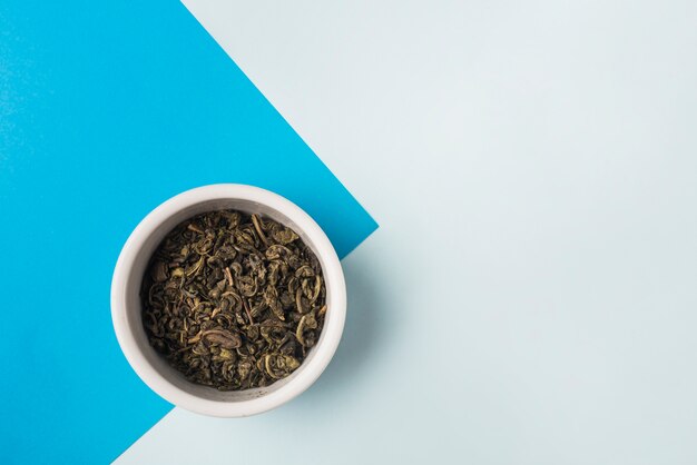 Tazón de té de hierbas secas en doble fondo azul y blanco