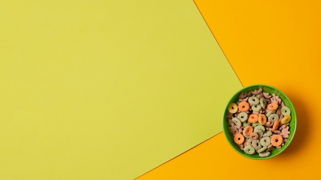 Tazón verde vista superior con cereales coloridos