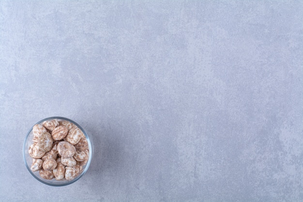 Un tazón de vidrio lleno de cereales saludables sobre fondo gris. Foto de alta calidad