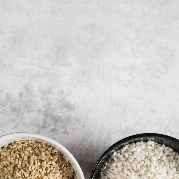 Tazones con arroz en escritorio blanco