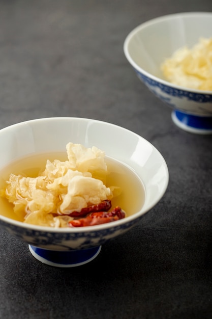 Tazones blancos y azules con sopa sobre un fondo gris