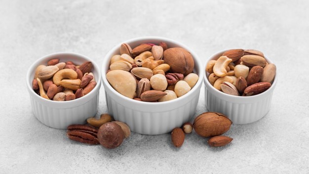 Tazones blancos pequeños llenos de variedad de nueces