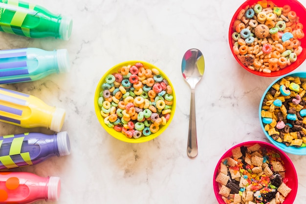 Foto gratuita tazones con cereales y botellas de leche en mesa.