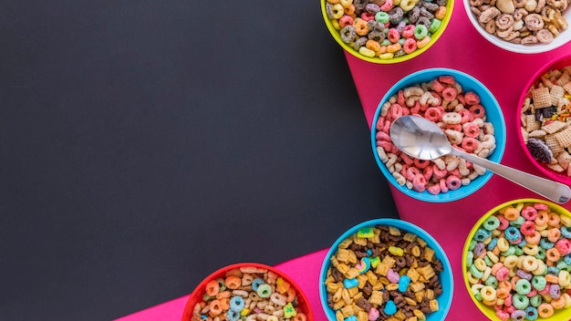 Foto gratuita tazones con diferentes cereales y cuchara en mesa