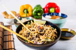 Foto gratuita tazones de fideos udon con carne de res y pimientos en el escritorio blanco