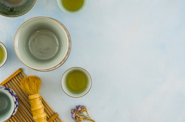 Tazones de té tradicionales y pincel de té sobre fondo blanco