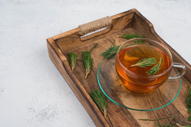 Té de agujas de pino en una taza sobre un fondo blanco texturizado espacio de copia vacío para bebida caliente de texto