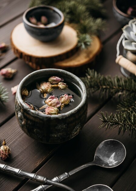 Té de alto ángulo con flores secas en taza rústica