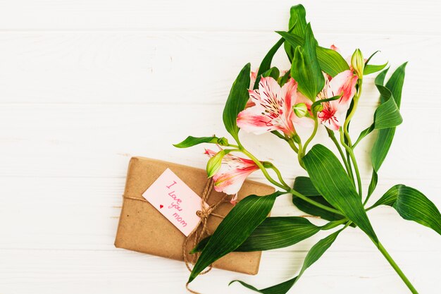 Te amo mamá inscripción con regalo y flores rosas.